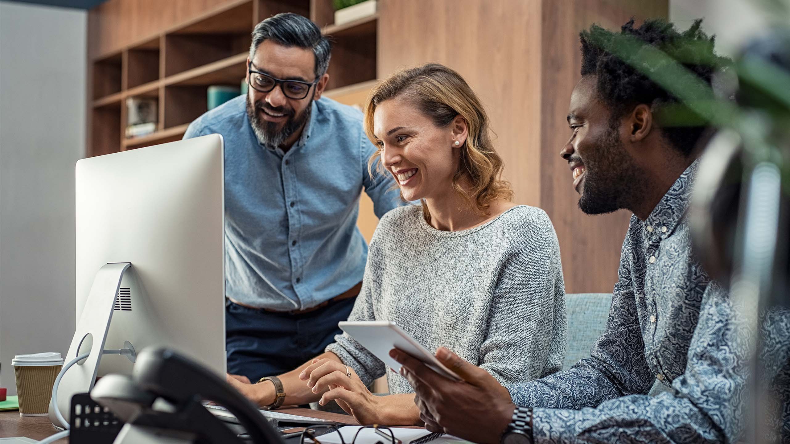 People working around a computer using and LMS